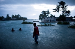 High tide regularly floods roads on Kiribati — a common occurrence that may be further exacerbated by sea-level rise caused by the expansion of warmer water and the addition of new water from melting ice. (© Ciril Jazbec)