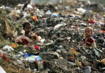 Children of rag-pickers stand amid a heap of garbage on the outskirts of New Delhi in 2006.