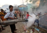 Children play in the fumes of a municipality fumigant sprayer in a slum area in the northeastern Indian city of Siliguri, Oct. 5, 2006.