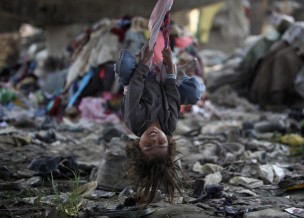 A child living in a slum plays on a swing under a bridge on the bank of Bagmati River in Kathmandu, Nepal, Oct. 17, 2011.