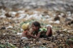 A girl plays with her brother as they search for usable items at junkyard near the Danyingone station in the suburbs of Yangon, Myanmar, in 2012.