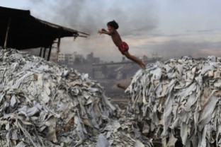 A child jumps on the waste products that are used to make poultry feed as she plays in a tannery at Hazaribagh in Dhaka, Bangladesh, in 2012.