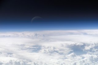 View of the crescent moon through the top of the earth's atmosphere. Photographed above 21.5°N, 113.3°E by International Space Station crew Expedition 13 over the South China Sea, just south of Macau (NASA image ID: ISS013-E-54329).